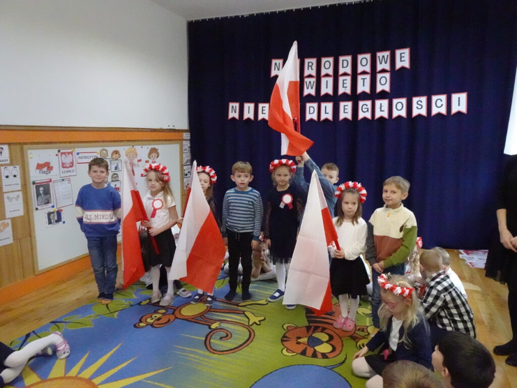 Grupka dzieci z flagami w rączkach. 