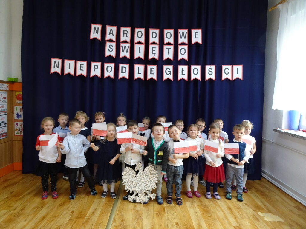 Zdjęcie grupowe. Dzieci w rączkach trzymają flagi Polski.