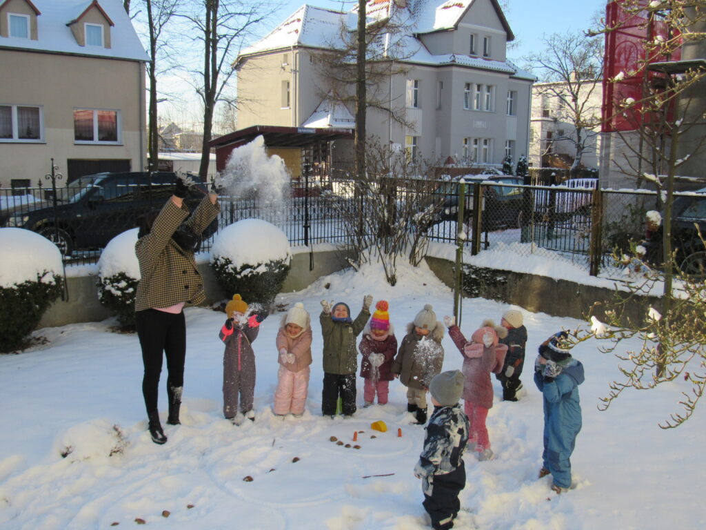 dzieci bawią sie śniegiem na dworze