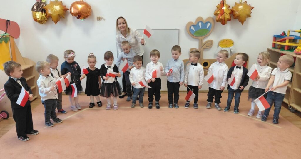 Zdjęcie grupowe. Dzieci trzymają w rączkach flagi Polski.