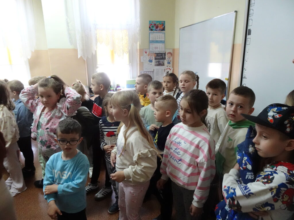 Zdjęcie grupowe. dzieci stoją przy tablicy w klasie szkolnej. 