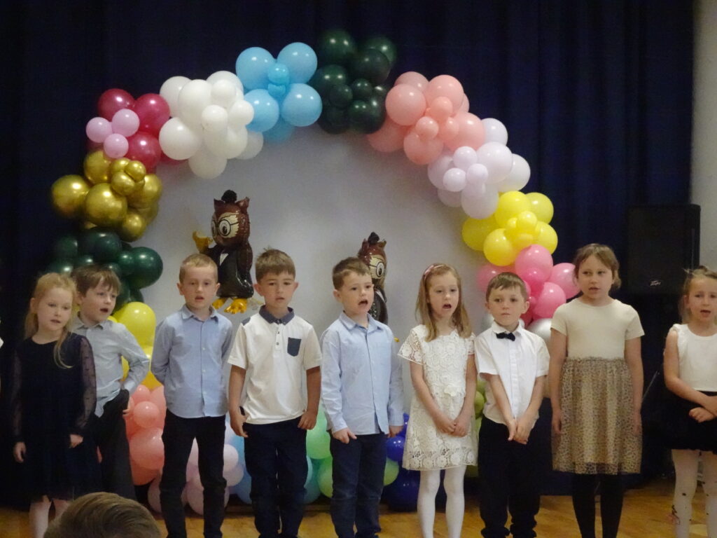 Zdjęcie grupowe. Dzieci ustawione w rzędzie podczas śpiewu piosenki. 