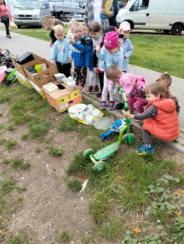 Zdjęcie na rynku. Dzieci oglądają przedmioty, które można kupić na rynku. 