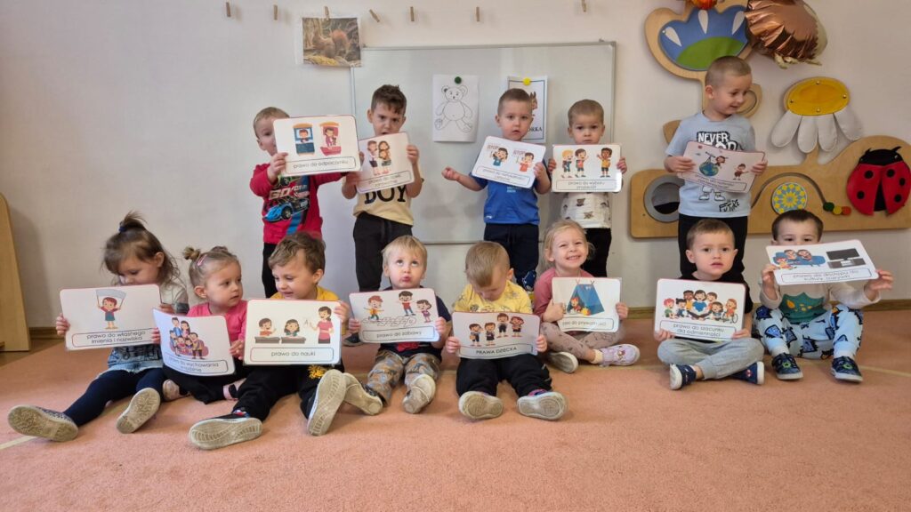 Zdjęcie grupowe. Dzieci w rączkach trzymają obrazki. 