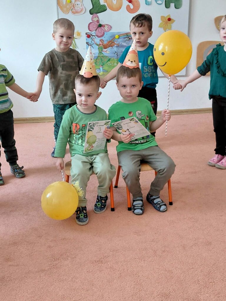 Zdjęcie urodzinowe. Dwóch chłopców w czapeczkach urodzinowych, 