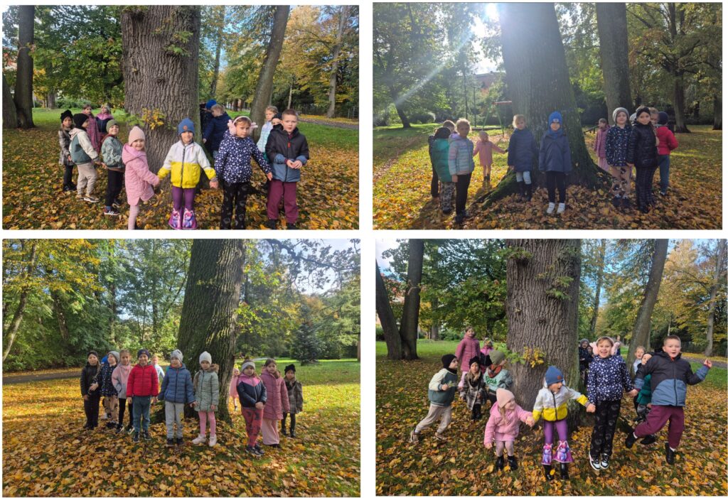 DZIECI STOJĄ W PARKU KOŁO DRZEWA DĘBU