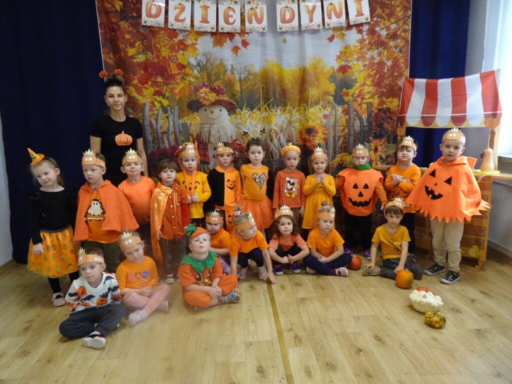 Zdjęcie grupowe. Dzieci w pomarańczowych strojach. 